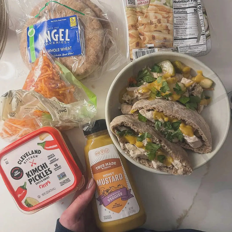 True Made Foods honey mustard served with pita sandwiches and fresh ingredients, showcasing a sugar-free condiment used beyond grilling.