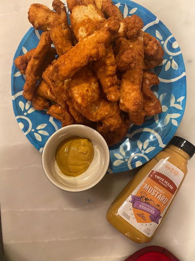 Plate of chicken tenders with a bowl of True Made Foods’ Honey Mustard dipping sauce.