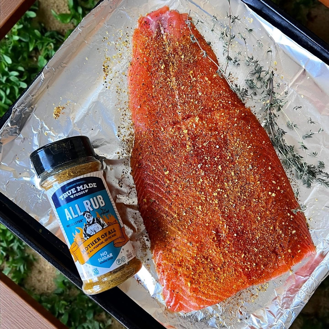 A salmon fillet seasoned with True Made Foods All Rub, ready to be grilled.