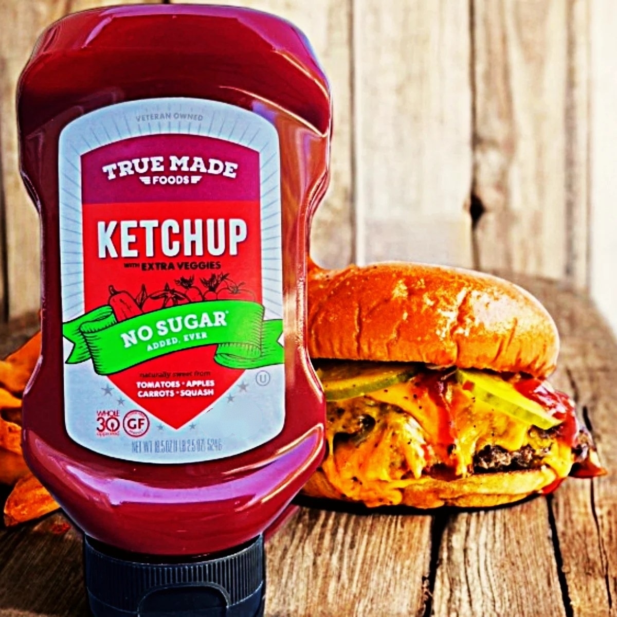 True Made Foods No Sugar Ketchup on a picnic table with a hamburger